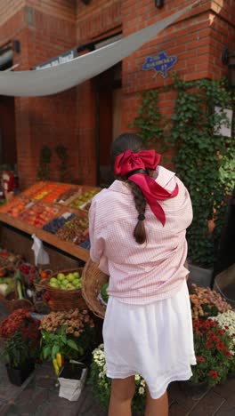 woman at a street market, taking photographs.