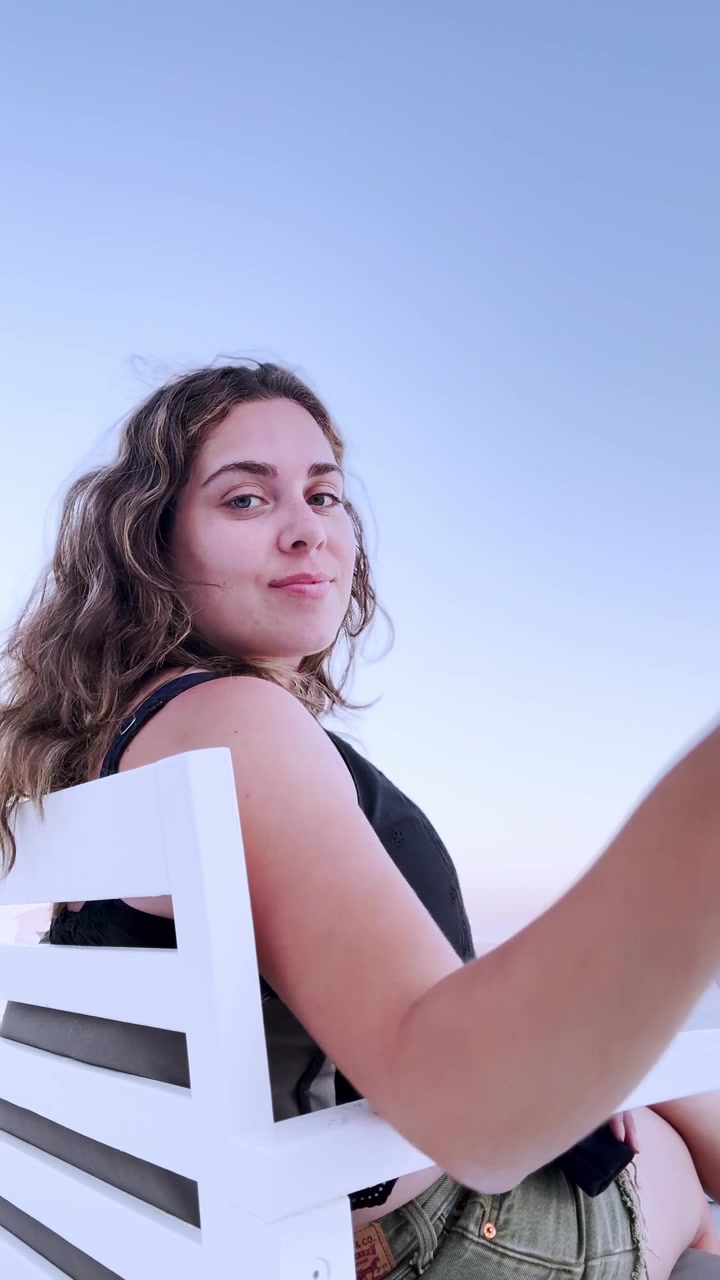 Young influencer enjoys vacation sunset in santorini