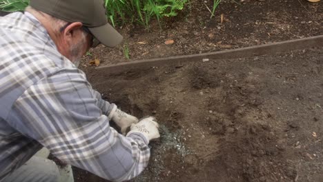 gardener installing sprinkler along botanical garden trail