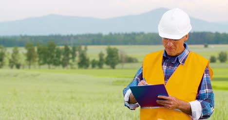 Engineer-Analyzing-Checklist-On-Clipboard-Amidst-Crops-At-Farm-5