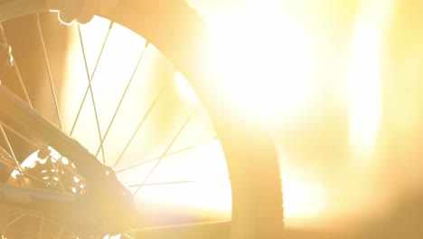 bicycle wheel turned by hand in slow motion with bright yellow light