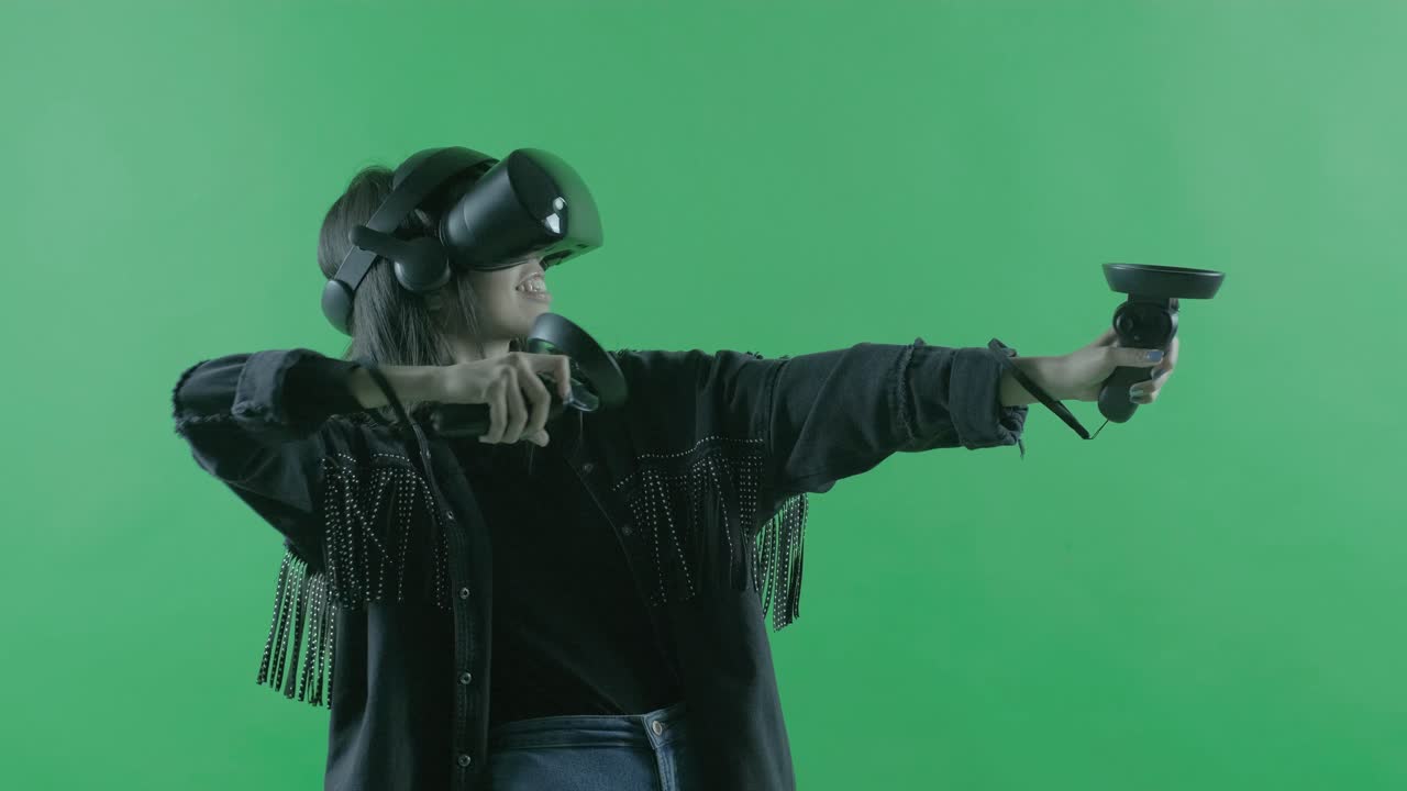 Giovane donna che gioca con il visore VR. Casco per la realtà virtuale su sfondo verde. Chroma Key.