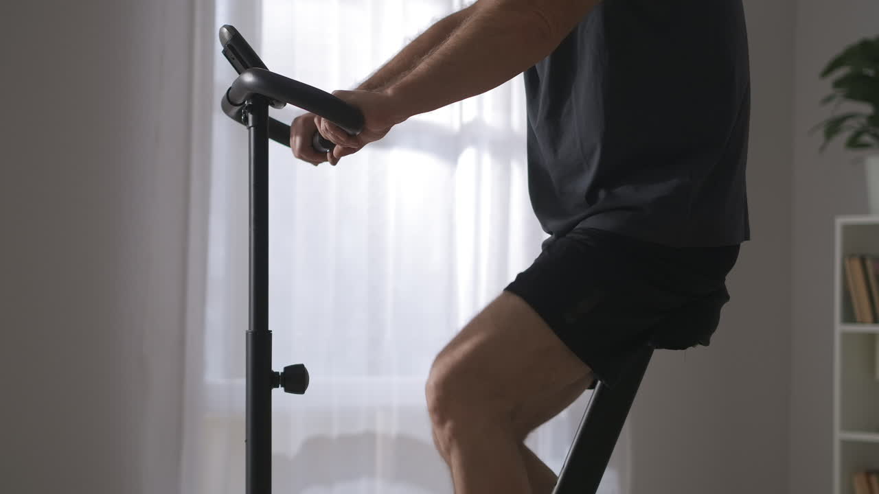 deportista adulto está entrenando en bicicleta estacionaria en casa primer plano del cuerpo preocuparse por la salud mantenerse en forma en casa acondicionamiento físico el fin de semana