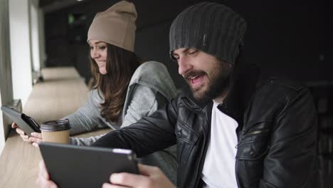 Work-meeting-in-agency.-Creative-man-and-woman-using-their-tablets-and-discuss-the-results-of-work.-Shot-in-4k