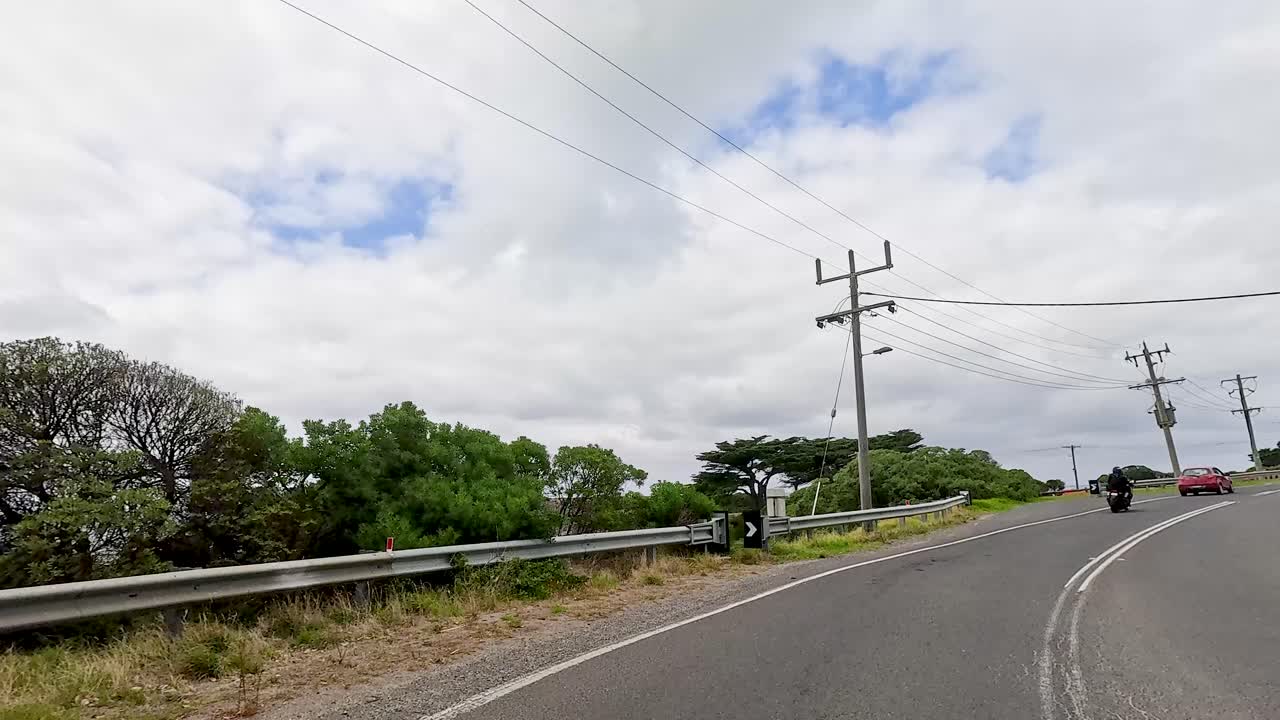 A 14-second drive along Great Ocean Road, showcasing lush greenery, clear skies, and a serene atmosphere
