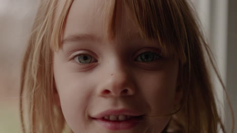 Slow-motion-portrait-of-a-little-girl-turning-toward-the-camera-and-smiling