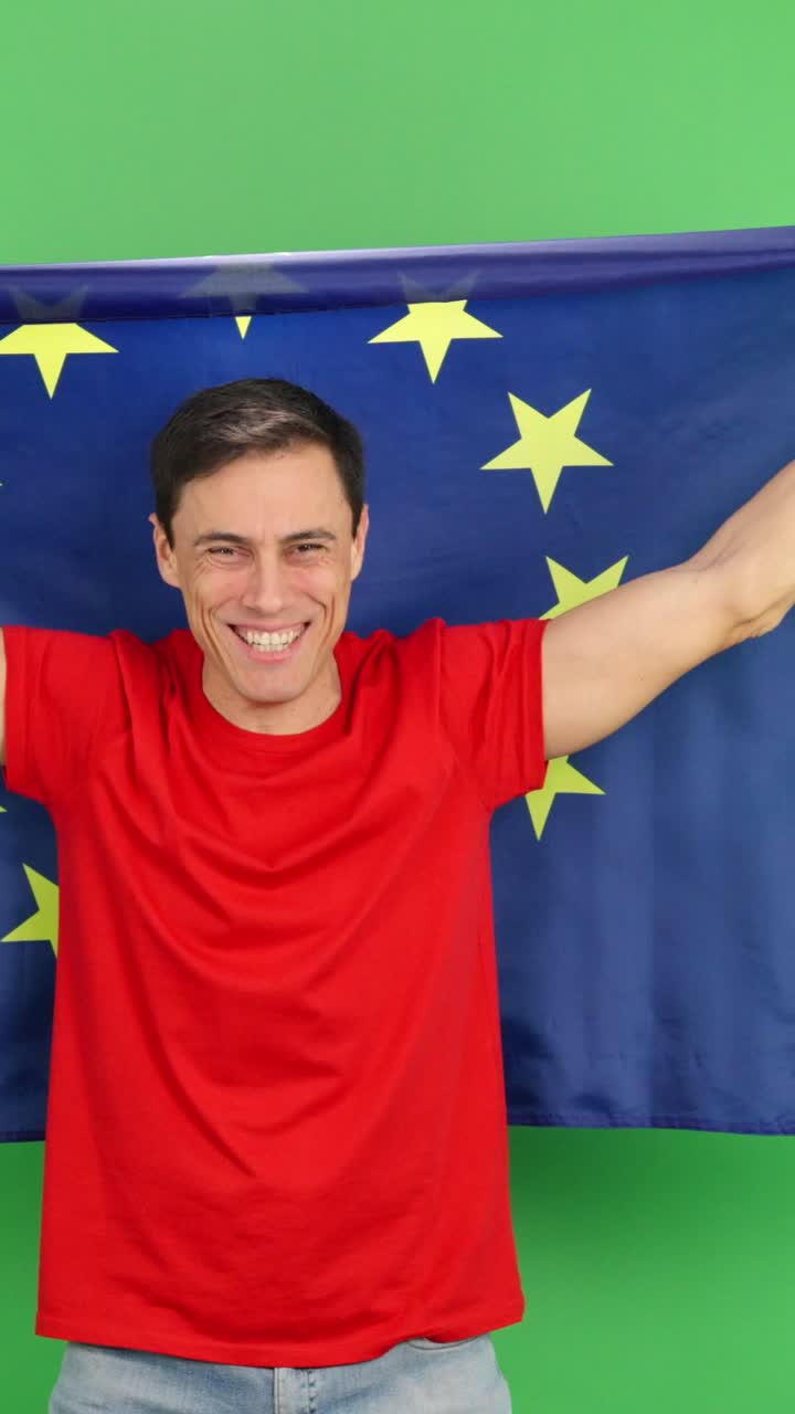 Tifoso sportivo che festeggia con la bandiera dell'Unione Europea su schermo verde