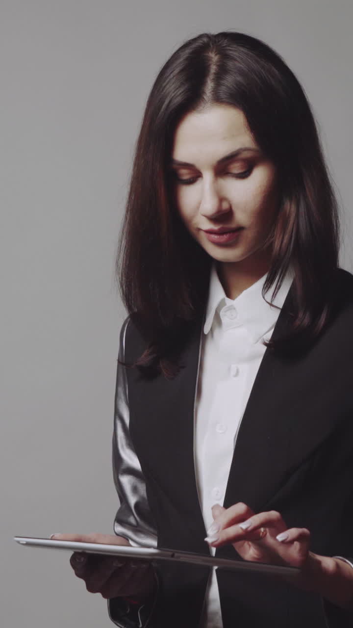 Woman using tablet. Business woman holding and using tablet in studio