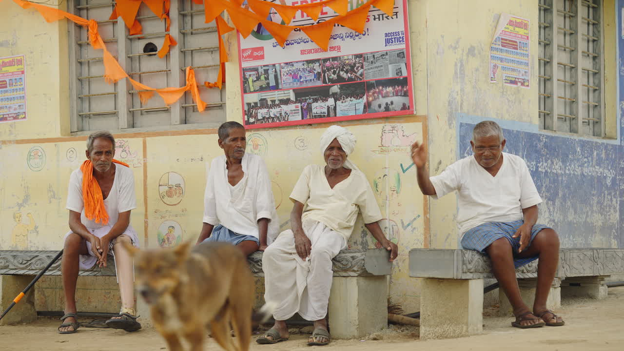 Men sitting on a bench near a building
