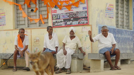 men sitting on a bench near a building