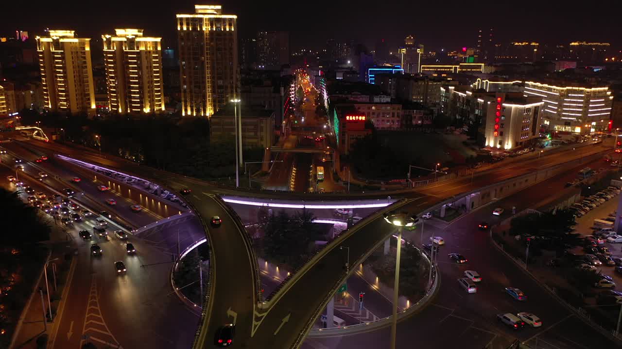 iluminación nocturna de la ciudad de qingdao tráfico ocupado intersección de carreteras panorama aéreo 4k china
