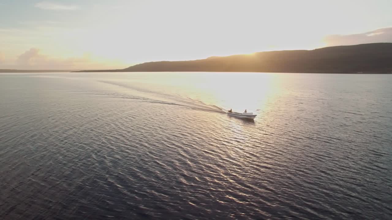 황금시간대에 이국적인 섬 해안을 따라 잔잔한 열대 바다에서 항해하는 보트, 공중 궤도