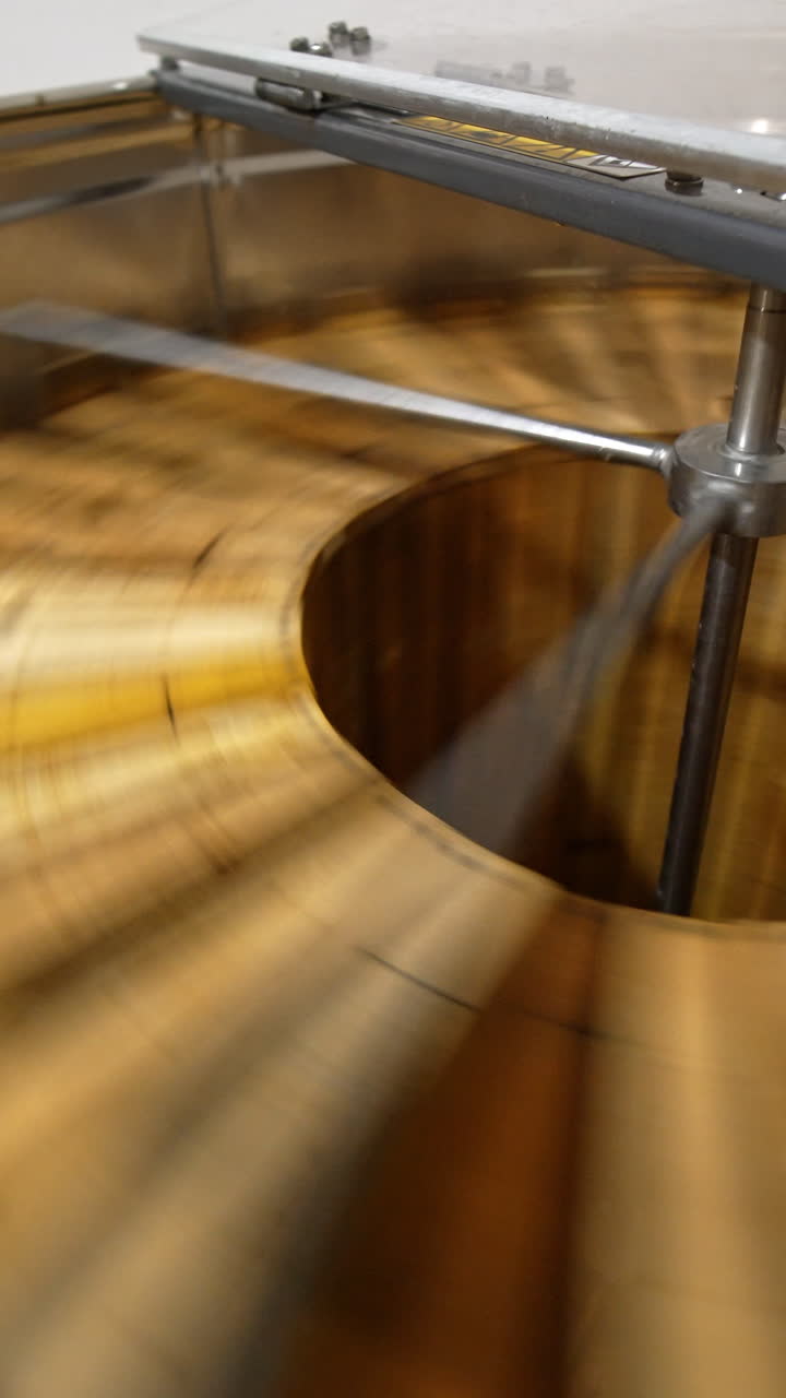 Getting the fresh healthy organic honey from the honeycombs. Switched on electric honey extracting machine with open lid close up. Vertical video