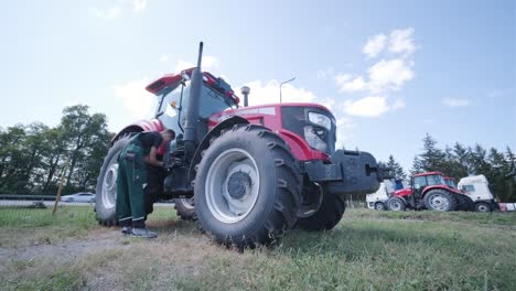 farmer mechanic repairing tractor. open tractor hood, engine. repair agricultural technology