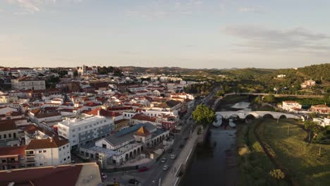 Low-flying-aerial-of-the-vivid-streets-of-Silves-and-the-Arade-river-in-Portugal