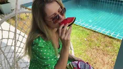 woman eating watermelon by the pool