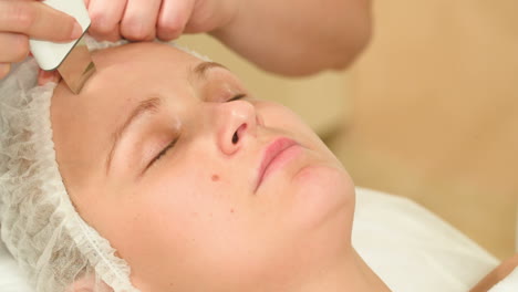 young woman taking facial treatments of ultrasonic cleaning