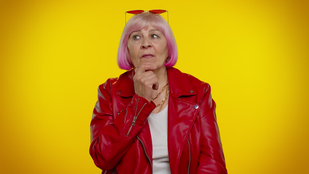 Thoughtful clever senior old grandma woman rubbing her chin pondering a solution, doubting question