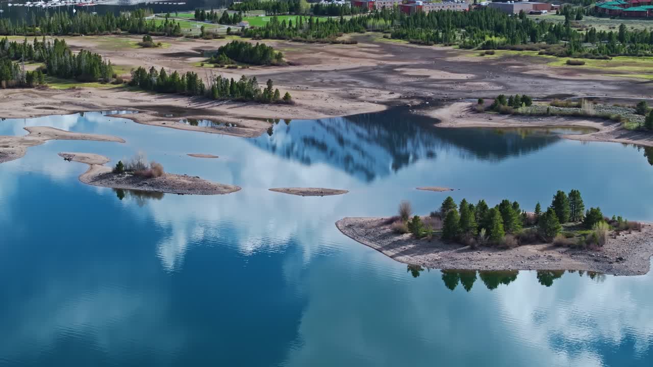 눈 인 산 뒤에 있는 구름은 콜로라도 주 프리스코에 있는 저수지의 물에 반사된다.