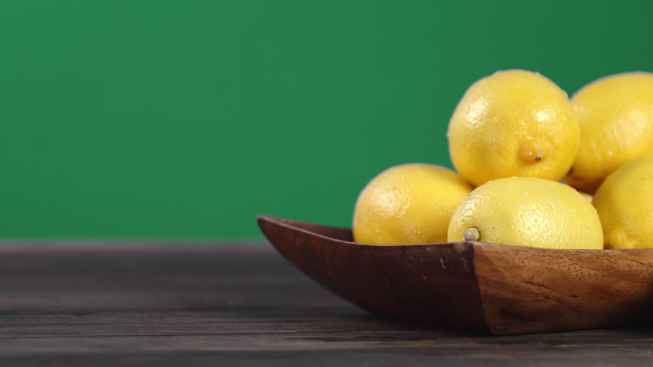 los limones jugosos en un plato de madera giran lentamente.