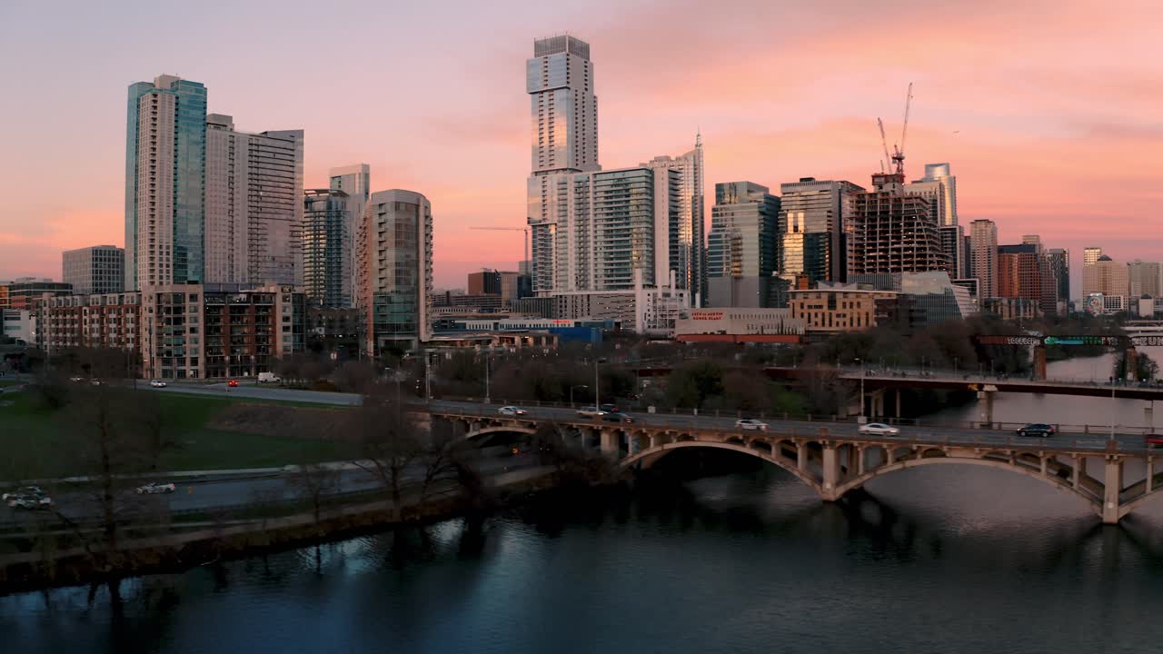 Skyline del centro di Austin, Texas, orbita aerea 4K sopra il Ponte Pedonale Lamar, traffico e Lago Ladybird al tramonto