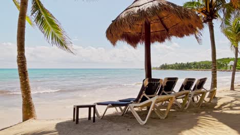 Cabana,-lounge-chairs,-and-swaying-palm-trees-in-Cancun-Mexico-on-the-Caribbean-Sea