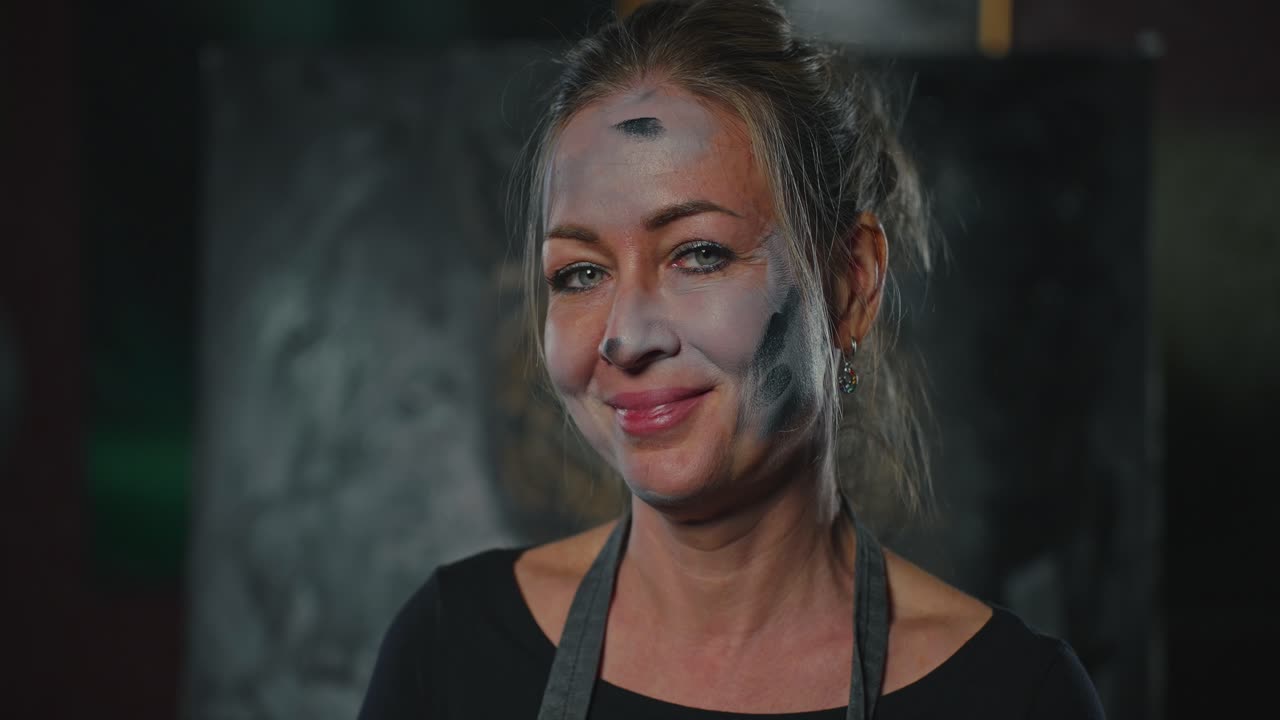 Woman Artist in Art Studio with Paint on Face