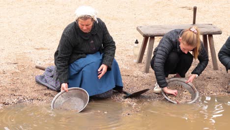 dos personas buscando oro en el agua