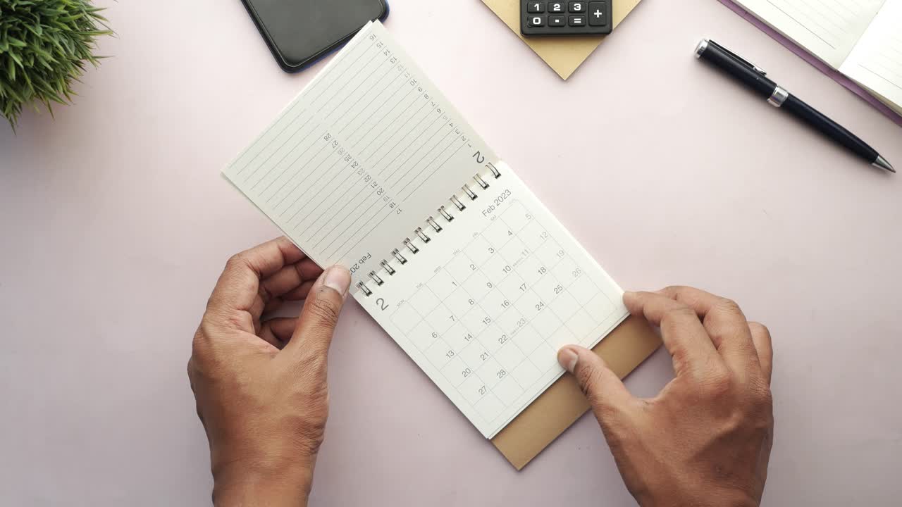persona que planea su horario con un calendario de escritorio