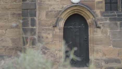 gothic looking old black wooden door in stone church building archway