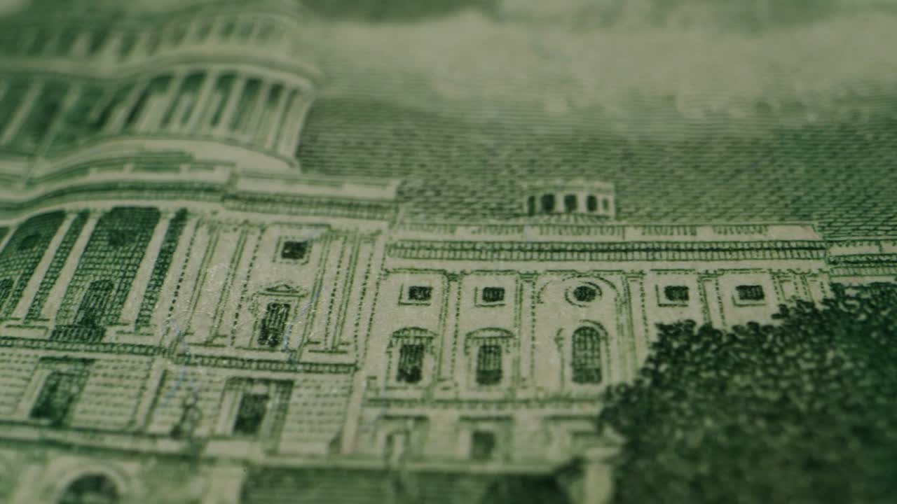 A closeup view of a fifty dollar bill on a polished wooden table, highlighting its intricate design