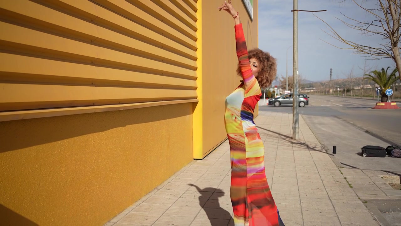 Una vibrante modelo de moda posa contra un colorido telón de fondo urbano