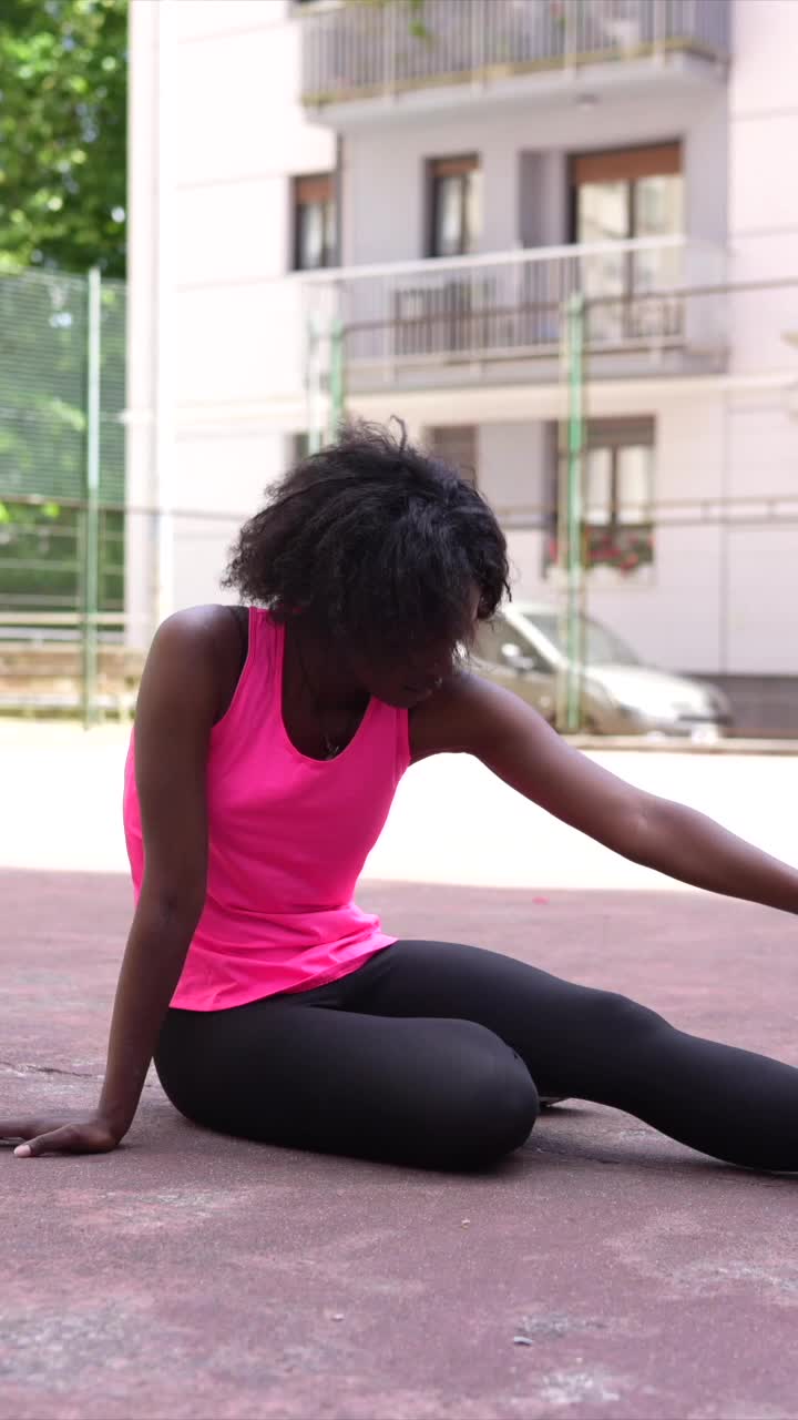 Donna che fa stretching su un campo da gioco
