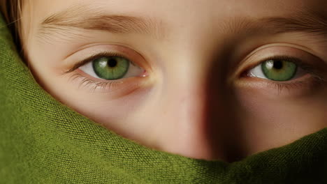 captivating green eyes peeking through green fabric