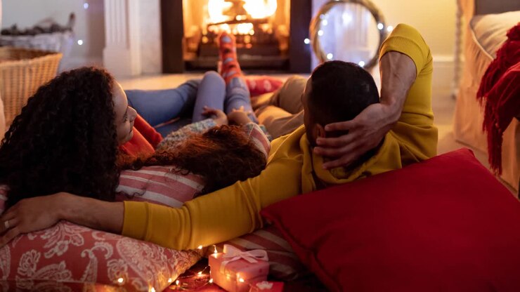 Animation of back view of african american family resting in front of fireplace at christmas time