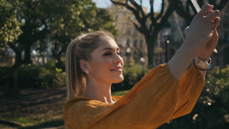 una joven elegante tomando fotos al aire libre.
