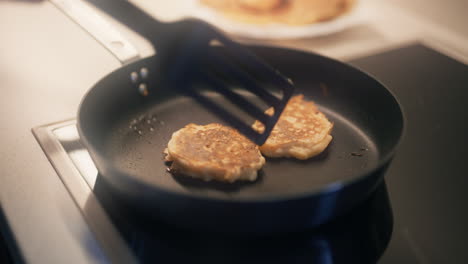 two pancakes baking in a pan in the kitchen