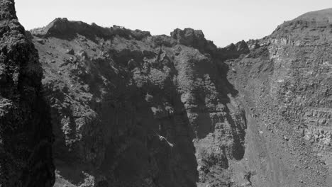 panning along the huge crater of the mount vesuvius volcano in black and white in pompeii, italy