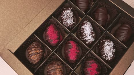 crafting chocolate candy gift box extreme close up camera move. assorted chocolates confectionery on white background slow motion, slider