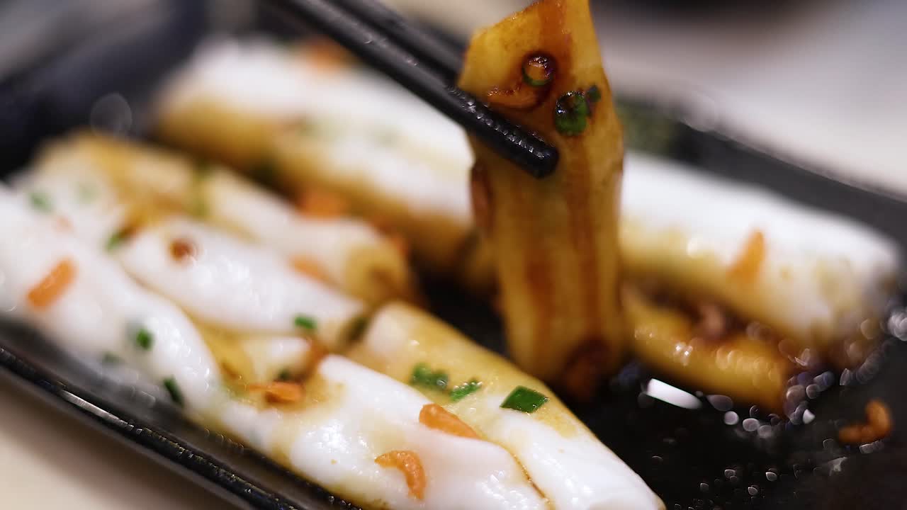 가락이 소스에서  누들 롤을 집어 들고