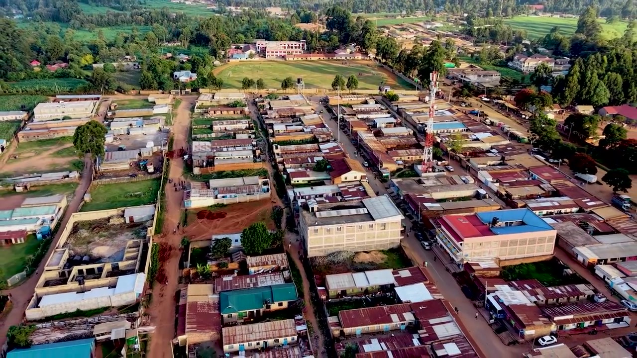 Drone che si allontana dal campo verso le povere baraccopoli del Kenya, campo da calcio della Coppa del Mondo, bambini poveri che giocano a calcio
