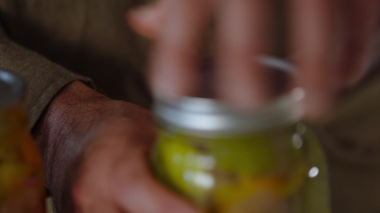 Closeup shot of closing of jar lid of pickled vegetables.