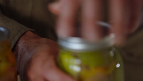closeup shot of closing of jar lid of pickled vegetables.