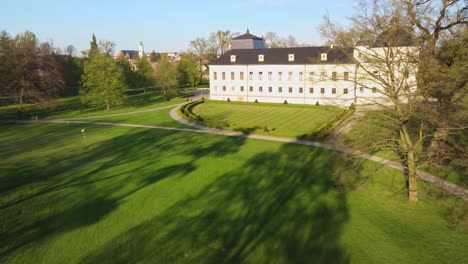 aerial dolly over grassy lawn to side of castle kravare in autumn, surrounded by scenic countryside, moraviansilesian region in czech republic