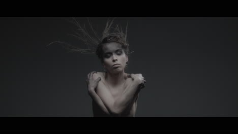 a woman dressed as mother nature moves slowly in a dance-like motion