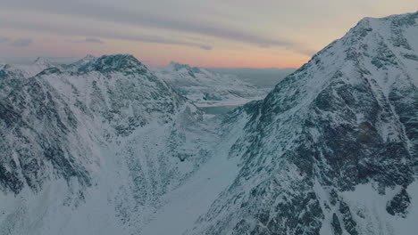 Aerial-view-towards-peaceful-Ramberg-glacial-rocky-mountain-sunrise-peaks-landscape,-Norway
