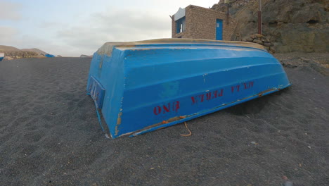 upturned old blue wooden boat on sandy shore in fuerteventura, canary islands, spain