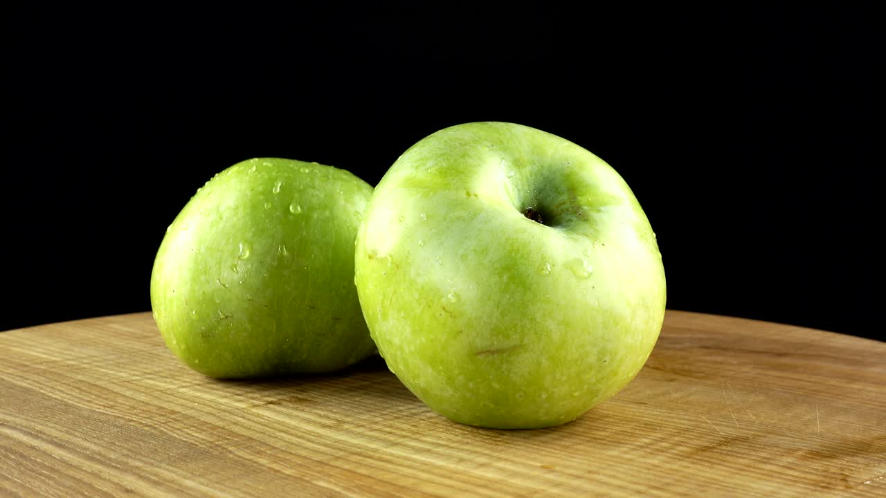 Æbler på sort baggrund. Skærebræt i bevægelse.