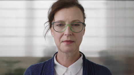 portrait of successful senior business woman boss looking serious confident at camera wearing glasses in office workspace background