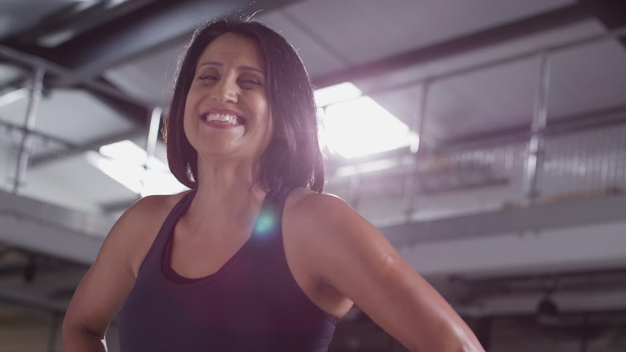 Portrait Of Smiling Mature Woman Wearing Fitness Clothing Standing In Gym Ready To Exercise